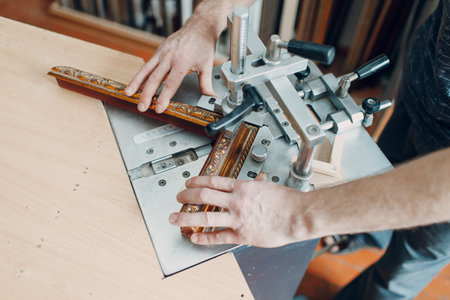 Framing Workshop. Assembling staples corners brackets baguette handmade picture frame at studio.の写真素材