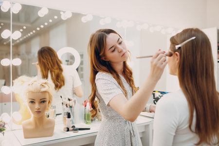Beautiful young woman applying make-up beauty visage by brush.の写真素材