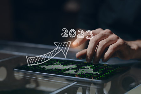 Business man hand on tablet PC screen with arrow growth chart graph businessman financial 2023 year...