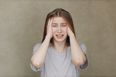 Portrait of young caucasian actress crying upset woman looking at camera against beige background. Acting testの写真素材