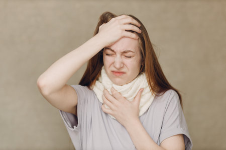 Young woman wearing scarf flu catarrh ill sick disease treatment coldの写真素材