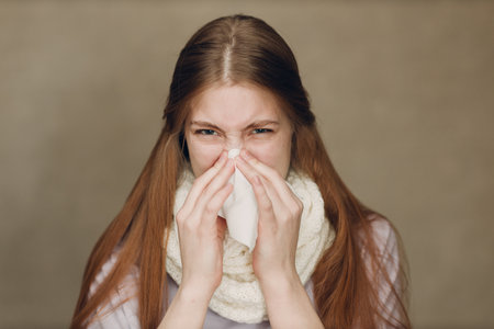 Young woman blowing nose has flu catarrh ill sick disease treatment coldの写真素材