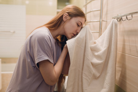 A woman wipes herself with a towel in the bathroom after washing.の写真素材