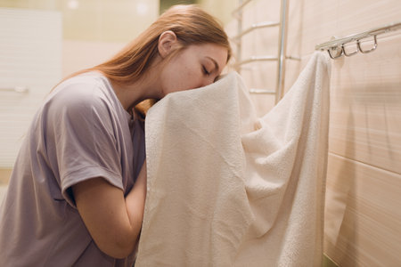 A woman wipes herself with a towel in the bathroom after washing.の写真素材