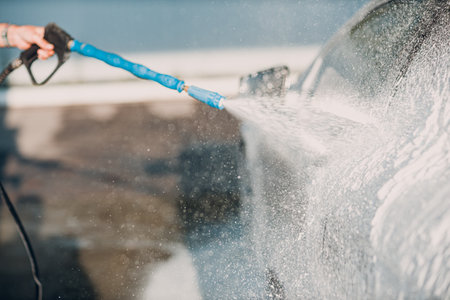 Worker washing car at self-service car washの写真素材