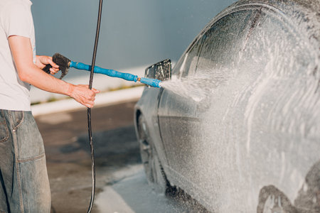 Worker washing car at self-service car washの写真素材