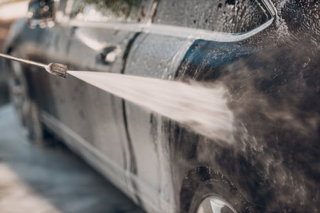 Worker washing car at self-service car washの写真素材