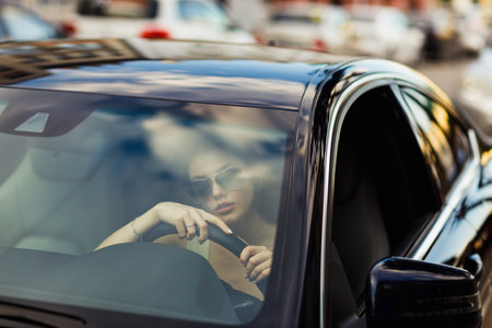 Happy woman driver at car smiling. Cute young happy brunette female driving car vehicleの写真素材