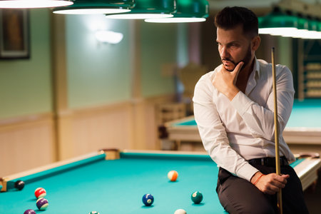 Billiard player calculate trajectory pathway at billard table or snooker american billiards pool...
