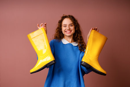 Young positive smiling girl holds in her hands a rubber bootsの写真素材