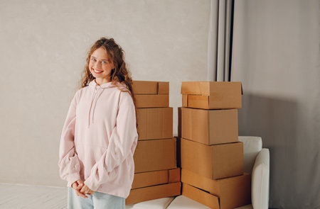 Happy young woman portrait moving with cardboard boxes to new estate home apartmentの写真素材