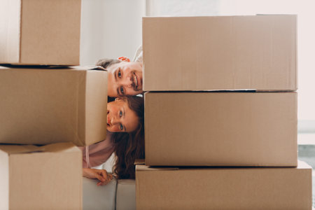 Happy young family couple man and woman portrait after moving cardboard boxes to new real estate...