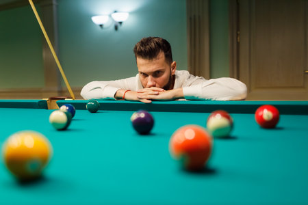 Billiard player calculate trajectory pathway at billard table or snooker american billiards pool...