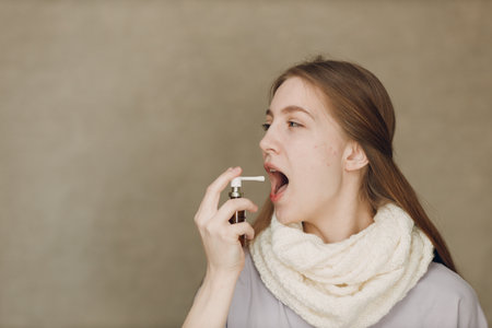 Young woman has flu catarrh ill sick disease treatment cold hold medicine nasal sprayの写真素材