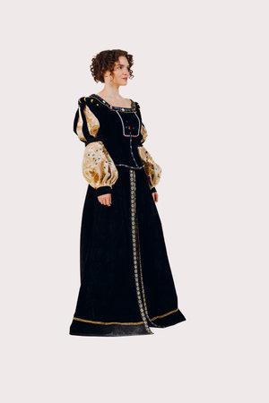 Portrait of a young aristocratic woman dressed in a medieval dress on white background. Side viewの写真素材