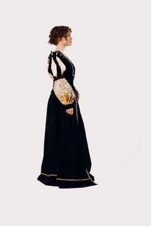 Portrait of a young aristocratic woman dressed in a medieval dress on white background. Side viewの写真素材