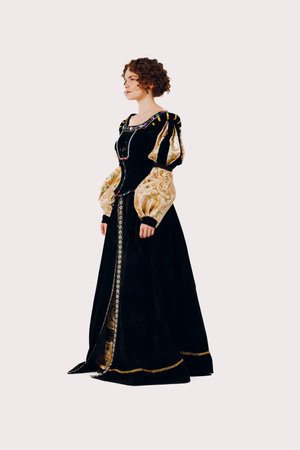 Portrait of a young aristocratic woman dressed in a medieval dress on white background. Side viewの写真素材