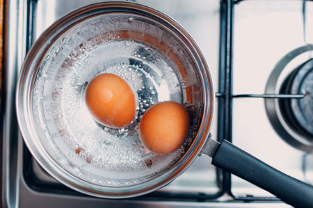 Saucepan stainless steel with boiling eggs breakfast in a water on a gas stove.の写真素材