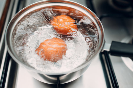 Saucepan stainless steel with boiling eggs breakfast in water on gas stove.