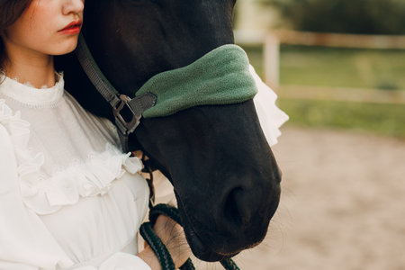 Woman portrait hugs her horse bridle at outdoors ranchの写真素材