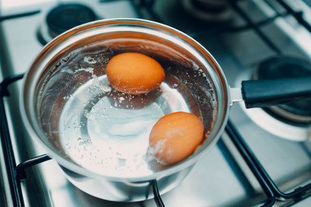 Saucepan stainless steel with boiling eggs breakfast in a water on a gas stove.の写真素材