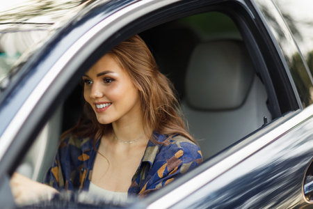 Happy woman driver at car smiling. Cute young happy brunette female driving car vehicleの写真素材