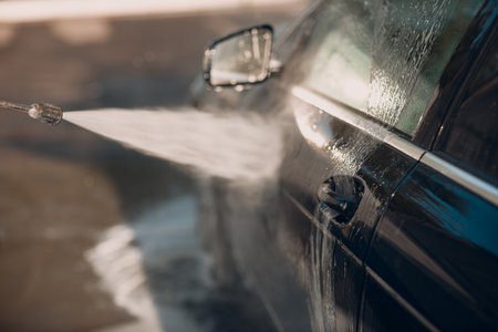 Worker washing car at self-service car washの写真素材