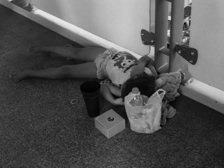 Little poor beggar girl sleeping on the walkway waiting for someone to give him a moneyのeditorial素材