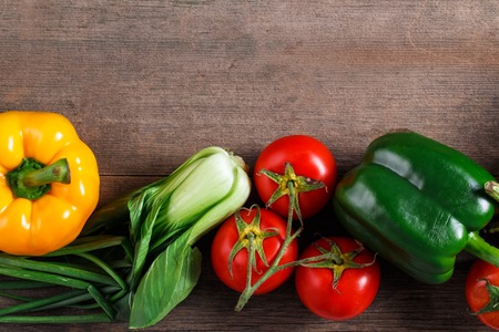 Vegetables on wood background with space for text. Farmers food. Bell pepper, onion, garlic, carrots and other vegetables.の写真素材