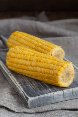 Two corns on cutting board closeupの写真素材