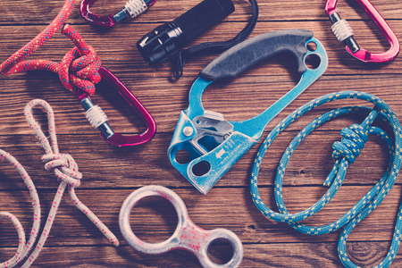 Rock climbing equipments on wooden background