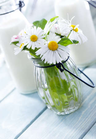 Milk and summer flowers on wood backgroundの写真素材