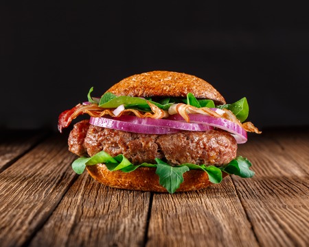 Burger with cheese close up. On wooden background.の写真素材
