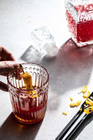 Human hand making red short drink over concrete table backgroundの写真素材