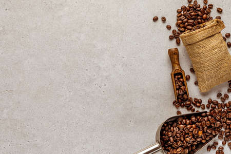Abstract coffee background with scattered beans from overturned burlap bag and spatula