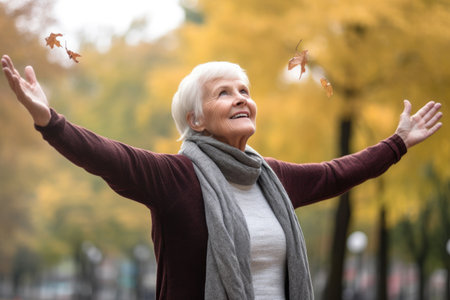 a senior woman standing outside with her arms outstretchedの素材