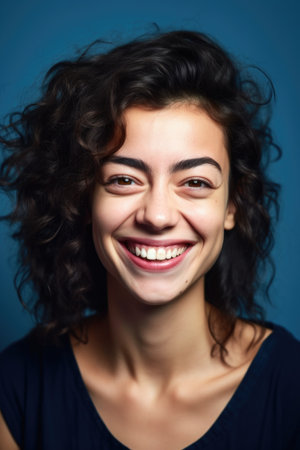 diversity, portrait and happy face of woman in studio on a blue background with a smileの素材