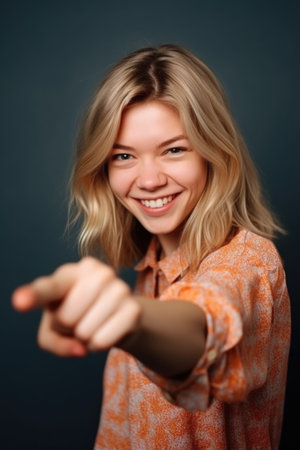 portrait of a cheerful young woman pointing at the cameraの素材