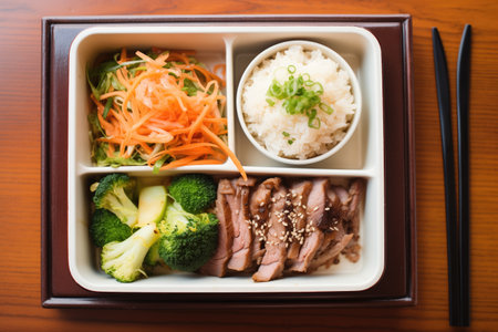 top-down shot of beef teriyaki in a bento box with sidesの素材