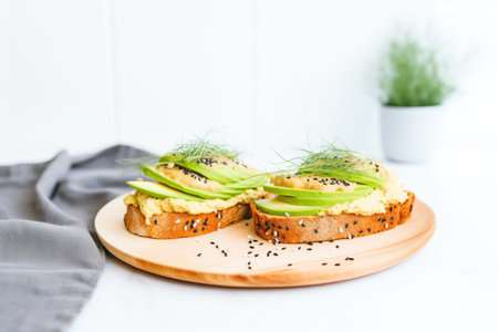avocado spread on bagel halves with sesame and poppy seedsの素材