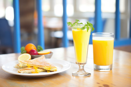 glass of orange juice next to breakfast crepesの素材