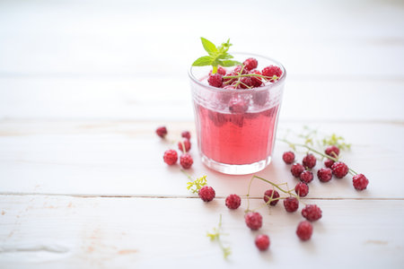 berry juice in clear cup, dewy berries scattered nearbyの素材