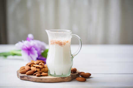 almond milk in a clear pitcher with whole almonds arranged aroundの素材