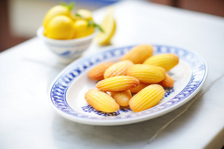 madeleines with lemon zest topping on a ceramic dish
