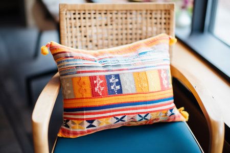 a close-up of a patchwork cushion on a woven matの素材