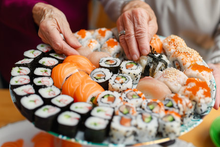 elderly couple sharing a platter of assorted sushi rollsの素材