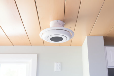 smoke detector fixed on a neutral colored ceilingの素材