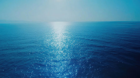 A clean, abstract blue sea gradient background with shimmering effects and no defined horizon.の素材
