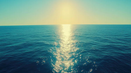 Calm sea with a gradient of sapphire blue to teal, reflecting golden sunlight near the edges.の素材