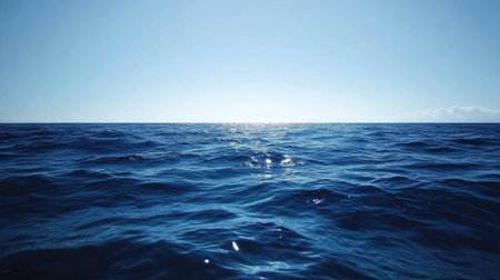 Blue sea gradient background blending oceanic shades under a cloudless, light-reflecting sky.の素材